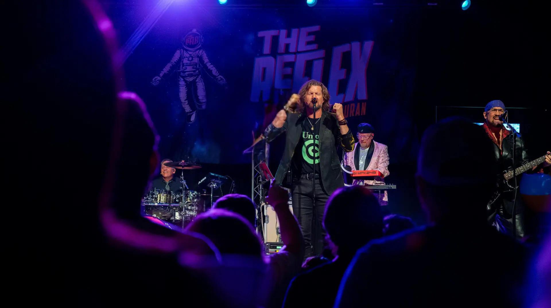 The REFLEX performing live on stage with crowd and lights